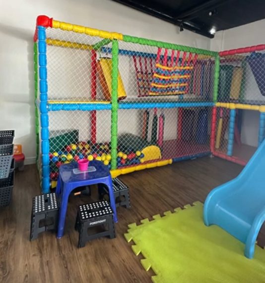 Brinquedoteca do REBU no Park Way, com estrutura de escalada colorida, piscina de bolinhas e escorregador.