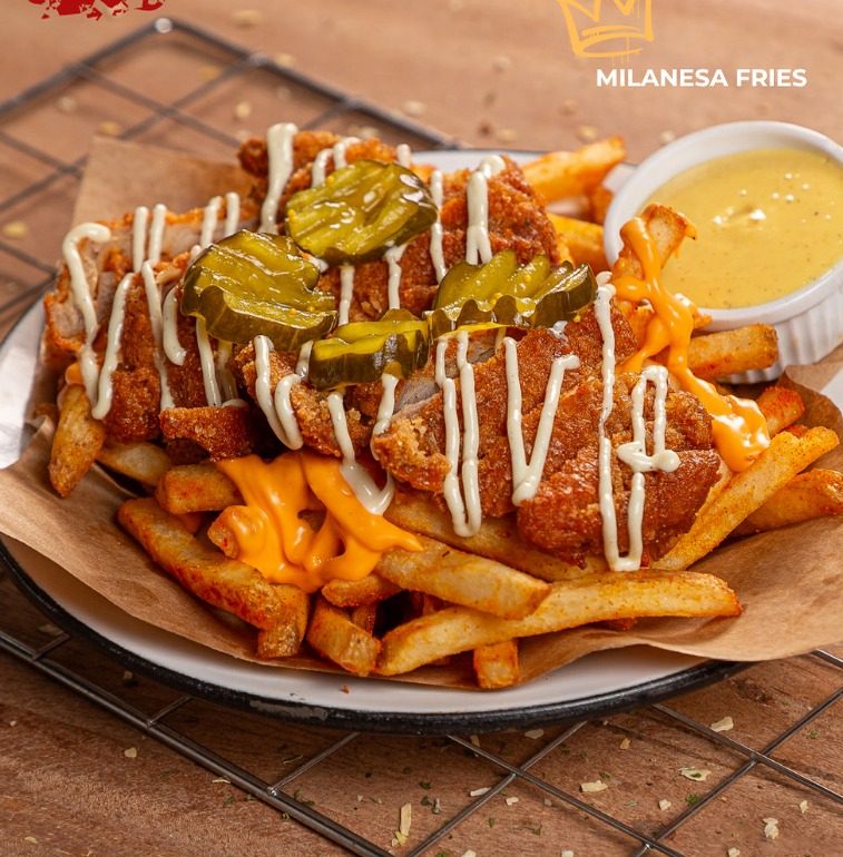 Milanesa Fries: fritas artesanais cobertas com molho de queijo, frango crocante empanado, maionese e picles.